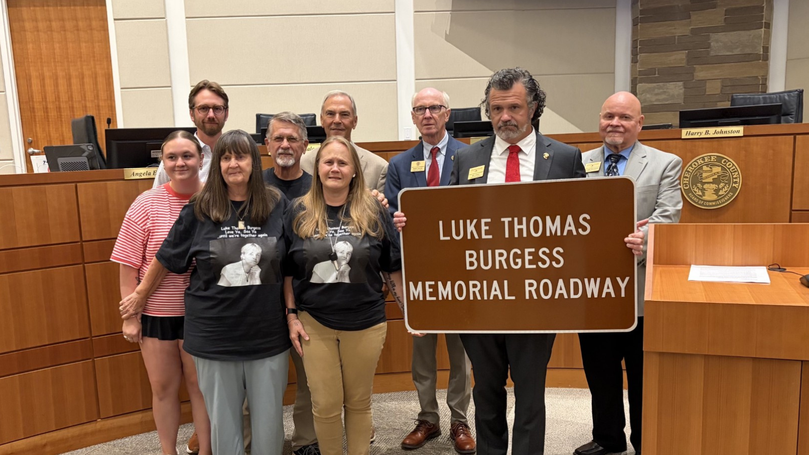 Image of Commissioner Cagle presenting road sign to family